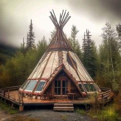 a large teepee sitting on top of a lush green forest