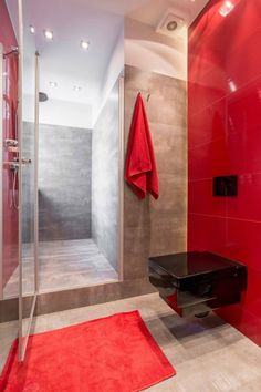 a bathroom with a red rug on the floor and a black table in front of it