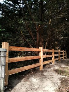 a wooden fence in front of some trees