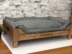 a dog bed made out of wood with a cushion on the top and bottom part