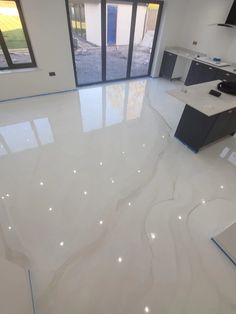 an empty kitchen with white marble floors and cabinets