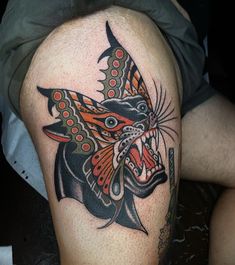 a tattoo on the leg of a person with a butterfly on it's head