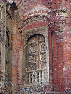 an old brick building with ornate carved wooden doors