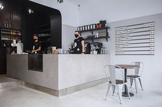 two men are behind the counter at a coffee shop