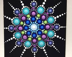 a painting on a white wall with black and blue circles in the center, surrounded by bubbles