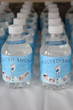 several bottled water bottles are lined up on a white tablecloth with snowman images