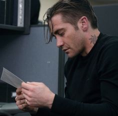 a man sitting at a desk with a knife in his hand