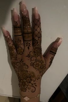 a woman's hand with henna tattoos on it and her hands in the shape of flowers