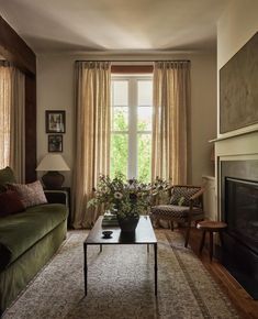 a living room filled with furniture and a fire place in front of a large window