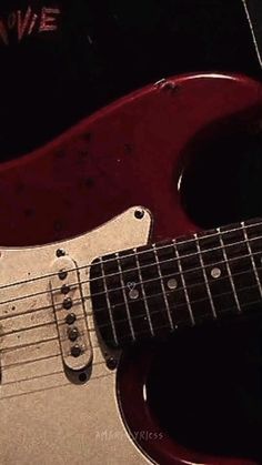 a red electric guitar sitting on top of a table