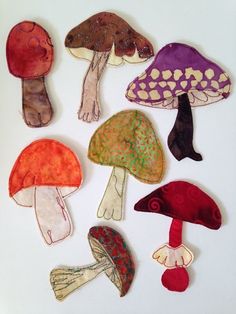 nine different colored mushrooms on a white surface