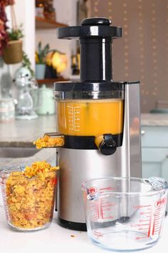 a food processor sitting on top of a counter next to a measuring cup and bowl