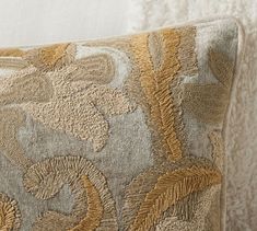 a close up of a decorative pillow on a bed