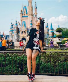 a woman sitting on top of a bench in front of a castle