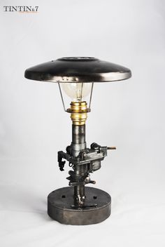 an old fashioned table lamp with a light bulb on it's base and a black shade