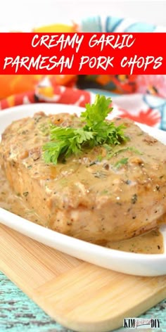 creamy garlic parmesan pork chops in a white dish on a wooden cutting board