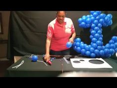 a woman standing in front of a table that has balloons on it and an e sign