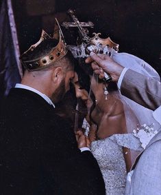 a bride and groom are getting married at the alter with a crown on their head