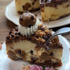 a piece of cheesecake with chocolate chips and whipped cream is on a floral plate