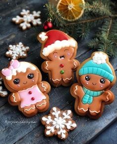 three decorated gingerbreads sitting next to each other on top of a wooden table