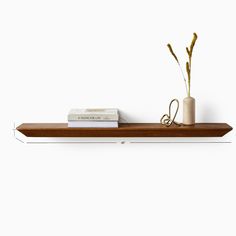 a wooden shelf with two books and a plant on top, along with a pair of scissors