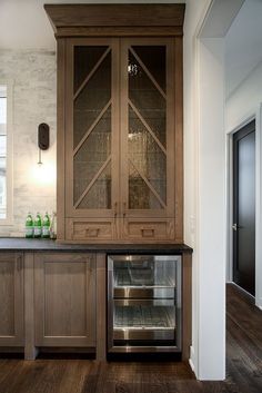 a kitchen with wooden cabinets and glass doors