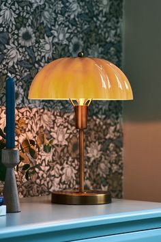 a table lamp sitting on top of a blue dresser