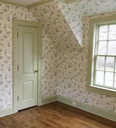 an empty room with wood floors and wallpaper