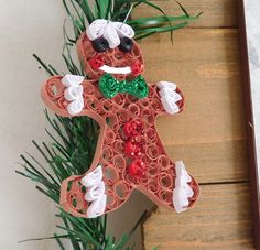 an ornament made to look like a gingerbread man with green and white decorations