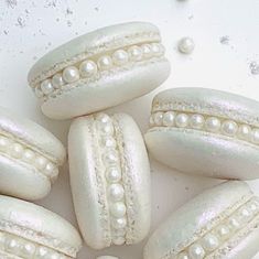 some white macaroons with pearls on them