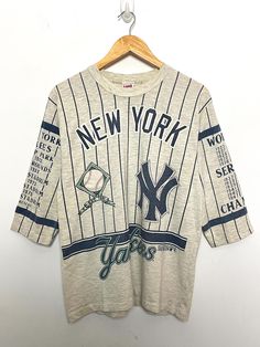 This tee shirt has a few small pinholes on the left arm and one on the lower back side. It also has some small marks on the lower front and back sides. (Please see photos for flaws) Measurements  Pit to pit: 19 1/2 inches  Top to bottom: 26 inches Yankees World Series, Book Merch, Long Gone, Graphic Tee Shirt, Great Team, Baseball Shirts, Mlb Baseball, Graphic Tee Shirts, World Series