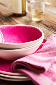 pink plates and napkins sit on a wooden table