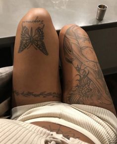 a person with tattoos on their legs laying down