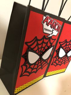 a red bag with black and yellow spider webs attached to it's sides