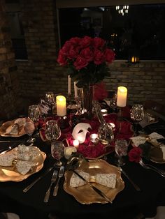 a table set with plates, silverware and candles for a formal dinner or party