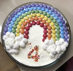 a rainbow cake with white frosting and sprinkles