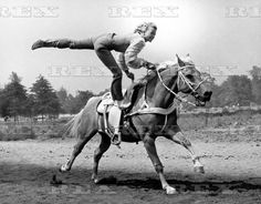 a man riding on the back of a horse while holding onto another person's leg