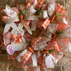 a wreath with carrots and bunny ears on it is hanging on a brick wall