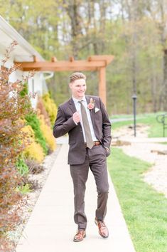 a man in a suit and tie walking down a sidewalk