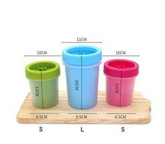 three different colored cups sitting on top of a wooden tray with measurements for each cup