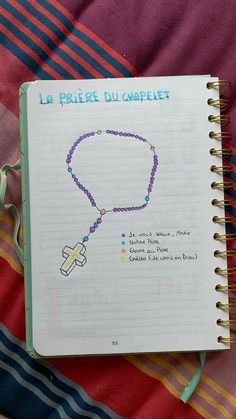 an open notebook with a rosary on it