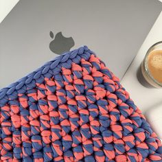 an orange and blue rug next to a laptop