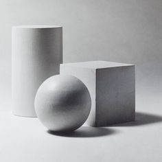 two white vases sitting next to each other in front of a gray background,