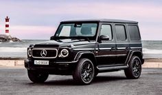 a black mercedes g - class is parked in front of the ocean and a lighthouse