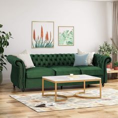 a living room with green couches and potted plants on the side table in front of it