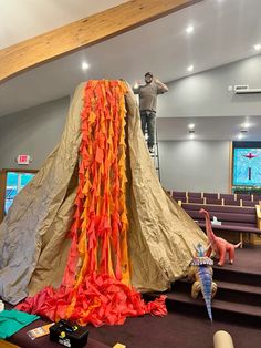 a man standing on top of a set of stairs next to a giant piece of paper