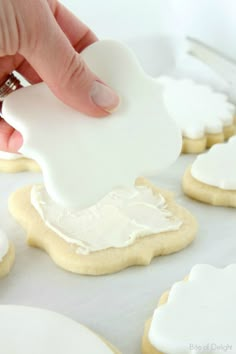 someone is decorating cookies with white icing