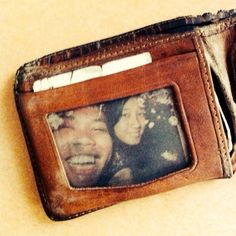 an old leather wallet with a photo on the front and two people in it sitting next to each other