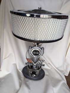 a lamp that is sitting on top of a white cloth covered table with a black shade over it