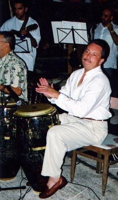 a man sitting on top of a chair next to a congregated drum set